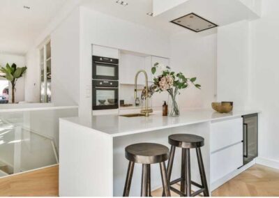 Kitchen with white cabinets and stools.